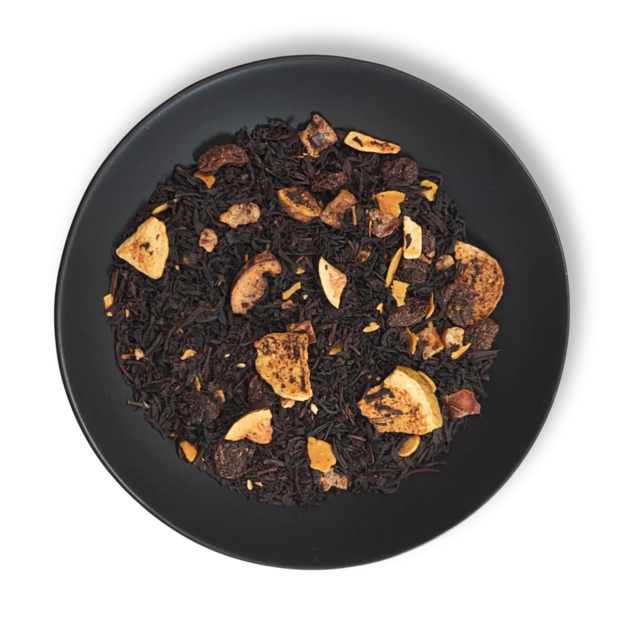 Caravan of Palmyra black tea blend close-up on black plate, featuring dried figs, dates, almond slices and loose leaf tea.