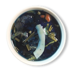 Azure Alchemy golden blue herbal tea infusion in white cup, vibrant deep blue color with lemongrass and coconut pieces floating
