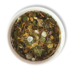 Top view of brewed Aether of Crete herbal tea showing whole Mediterranean herbs, citrus peel and dittany leaves in golden infusion.