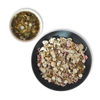 Loose leaf Aether of Crete organic herbal tea blend with Cretan dittany, chamomile, sage and citrus peel next to freshly brewed cup.