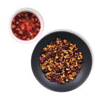 Crimson Orchard loose-leaf fruit tea blend with apple pieces, hibiscus petals and cranberries beside brewed red infusion