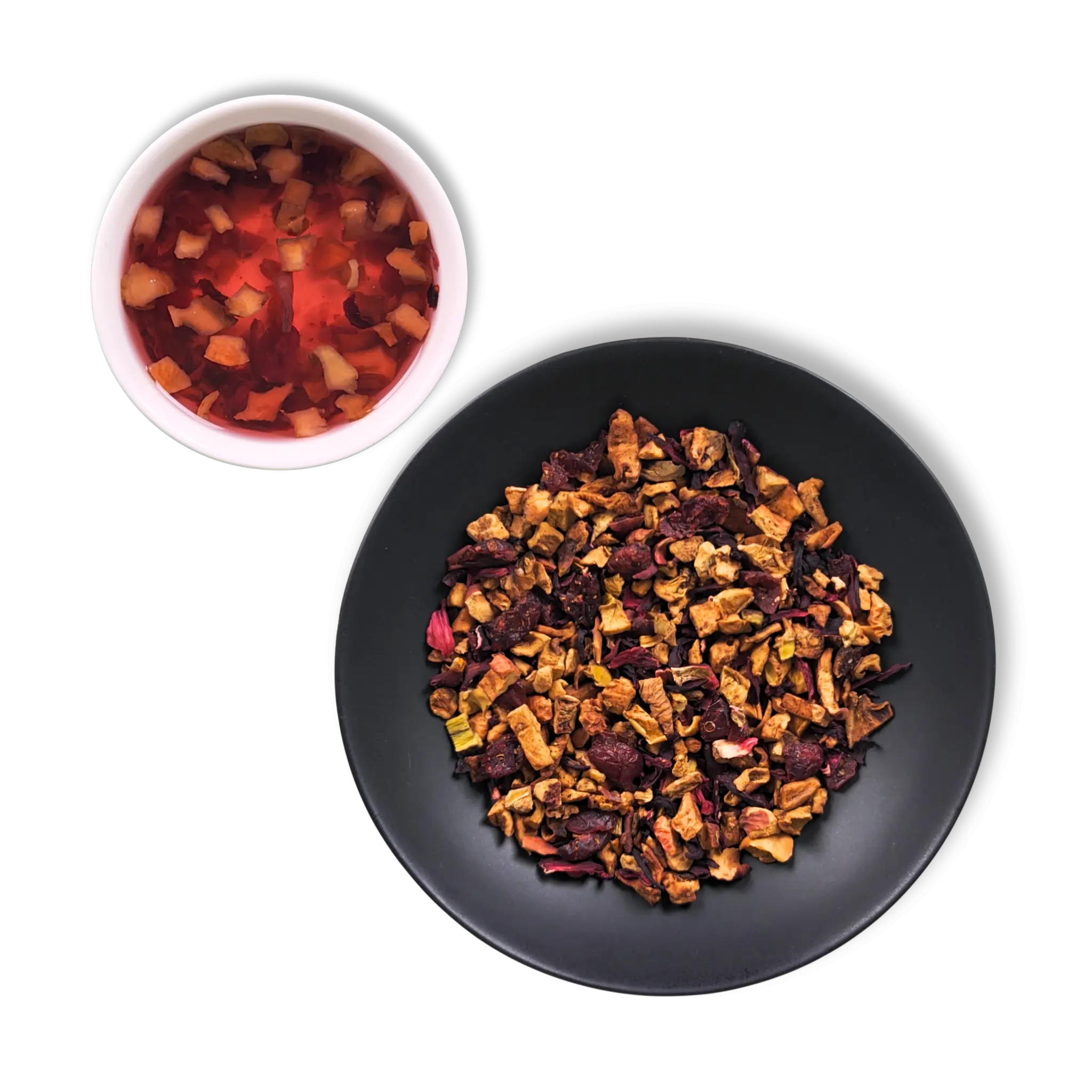 Crimson Orchard loose-leaf fruit tea blend with apple pieces, hibiscus petals and cranberries beside brewed red infusion