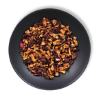 Crimson Orchard loose-leaf fruit tea blend with apple, hibiscus and cranberry displayed on a black plate