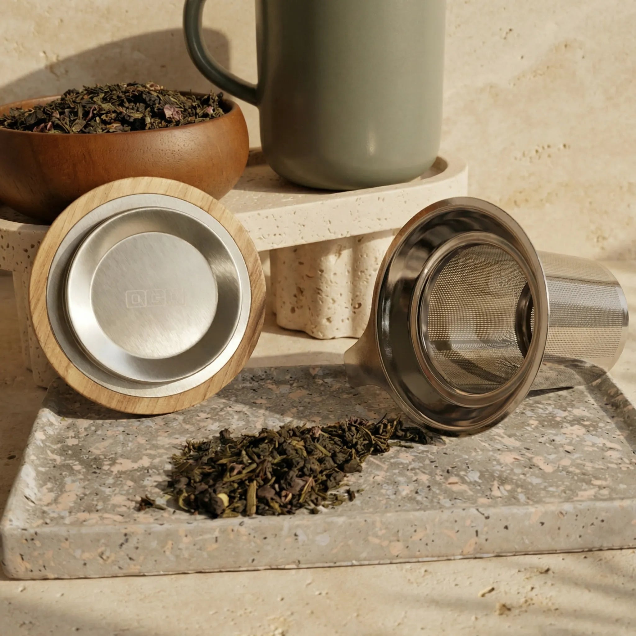 Juliet Almond tea mug set showing stainless steel infuser and acacia lid displayed with loose tea.