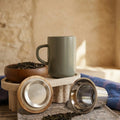 Juliet Almond Stoneware Tea Mug 475ml with stainless steel infuser and acacia lid next to a tea bowl.