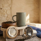 Juliet Almond Stoneware Tea Mug 475ml with stainless steel infuser and acacia lid next to a tea bowl.