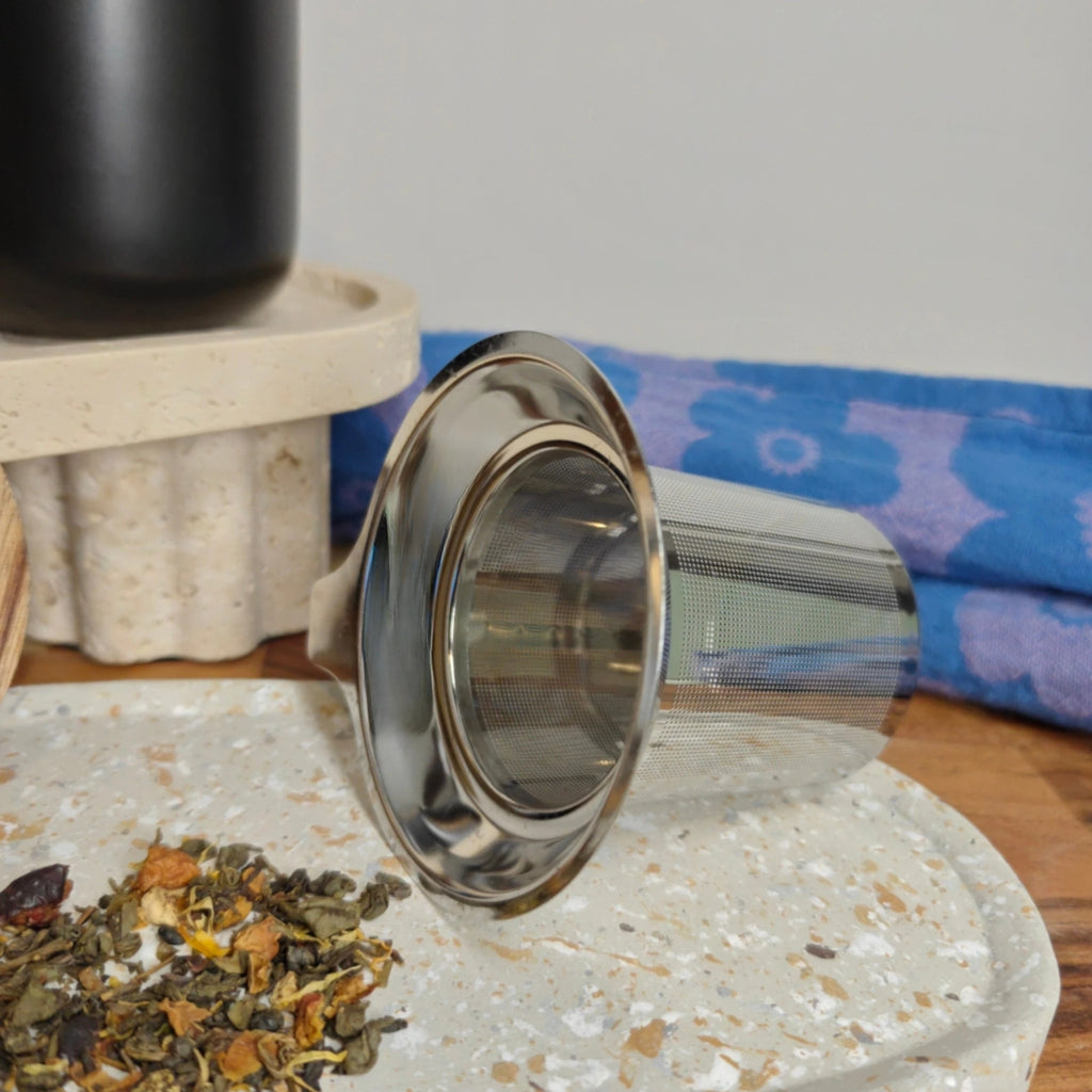 Detail of fine mesh stainless steel infuser for loose-leaf tea and acacia lid for the Juliet mug.