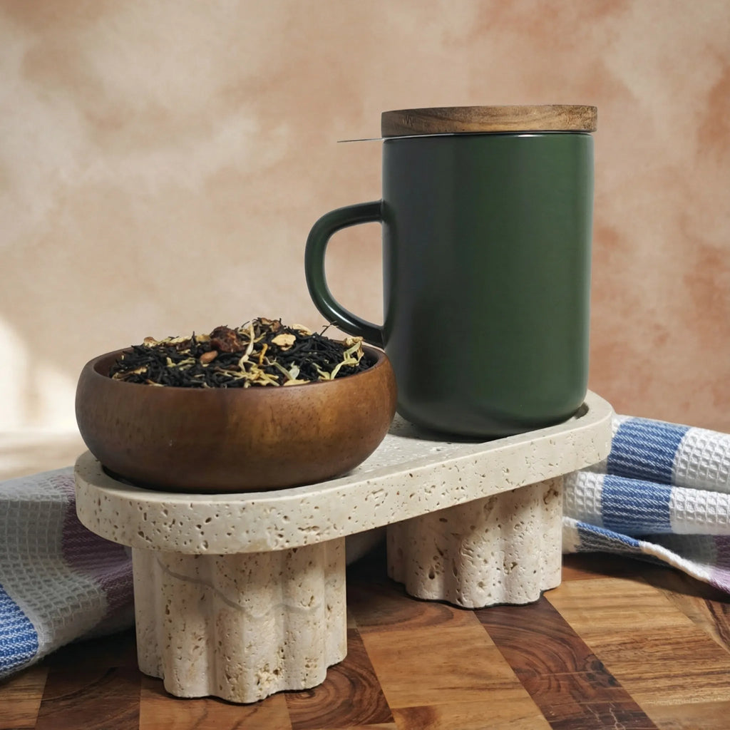 Khaki green stoneware Juliet mug with closed acacia wood lid for heat retention sitting on a terrazzo stand.