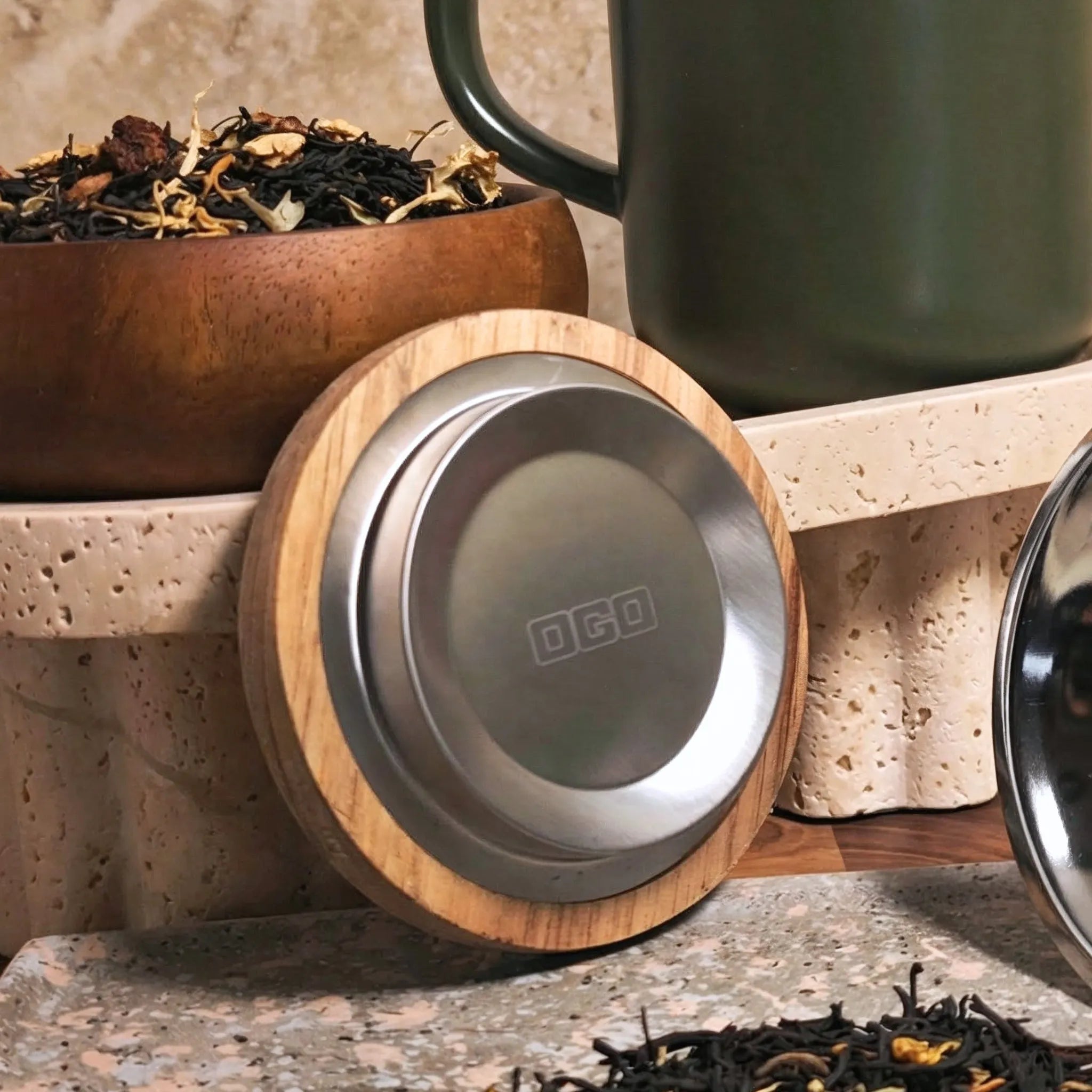 Close-up of acacia wood lid with stainless steel insert and Khaki stoneware tea mug background.