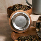 Close-up of acacia wood lid with stainless steel insert and Perle stoneware tea mug.