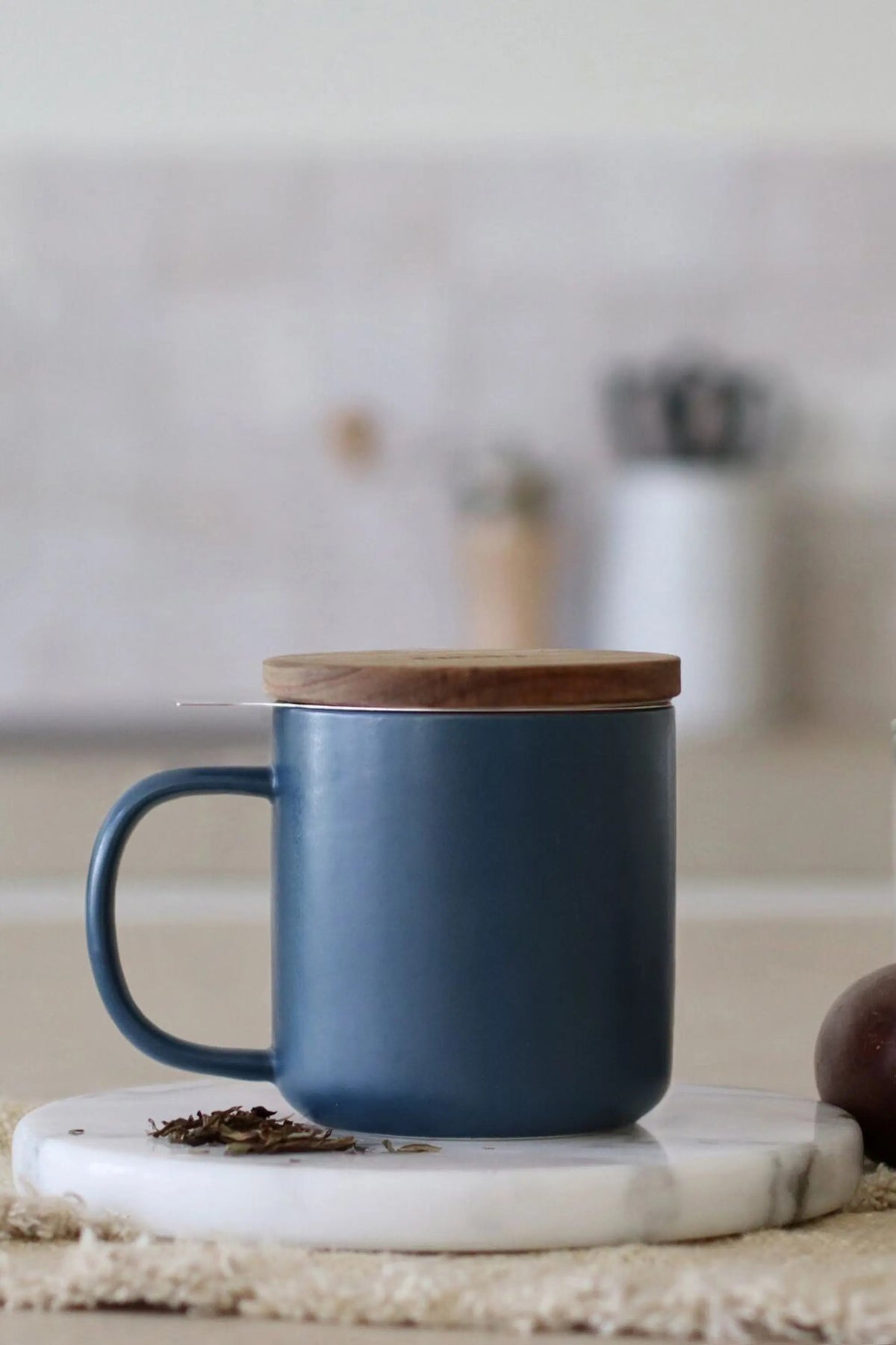 Juliet Blue 300 ml tea mug with acacia lid on a table with loose-leaf tea