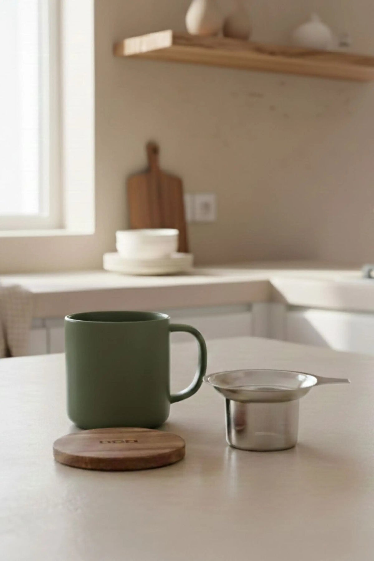 Juliet Khaki 300 ml tea mug with acacia lid on a table with loose-leaf tea