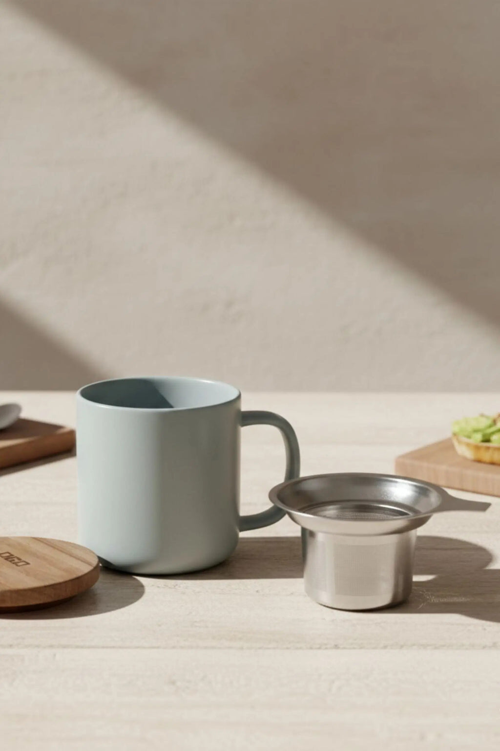 Juliet Perle 300 ml tea mug with acacia lid on a table with loose-leaf tea