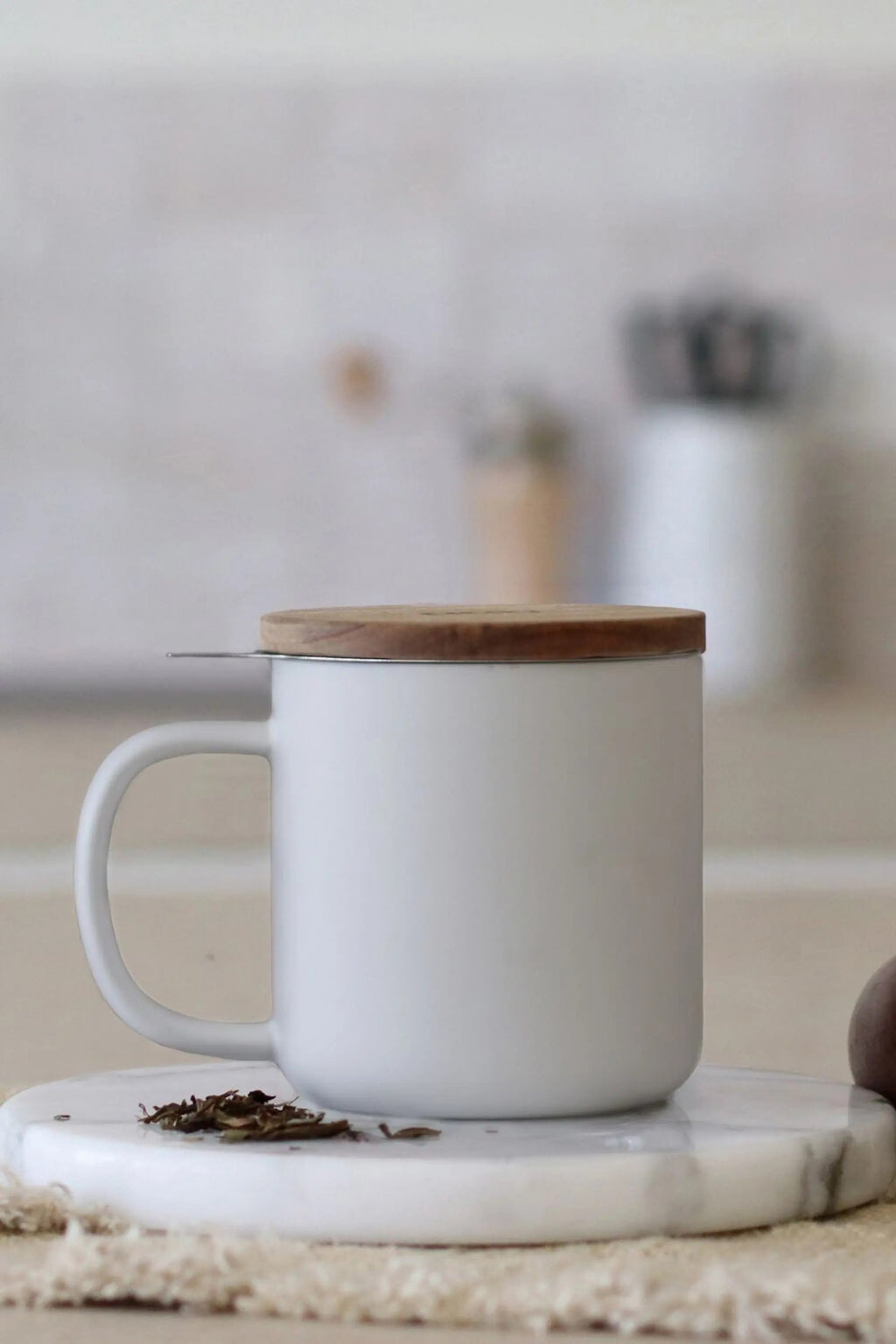 Juliet White 300 ml tea mug with acacia lid on a table with loose-leaf tea
