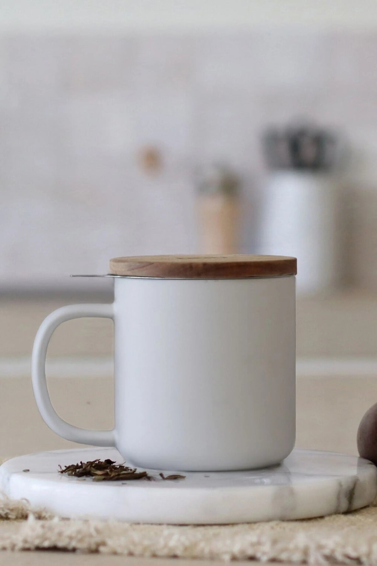 Juliet White 300 ml tea mug with acacia lid on a table with loose-leaf tea