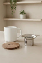 Juliet White 300 ml tea mug with acacia lid on a table with loose-leaf tea