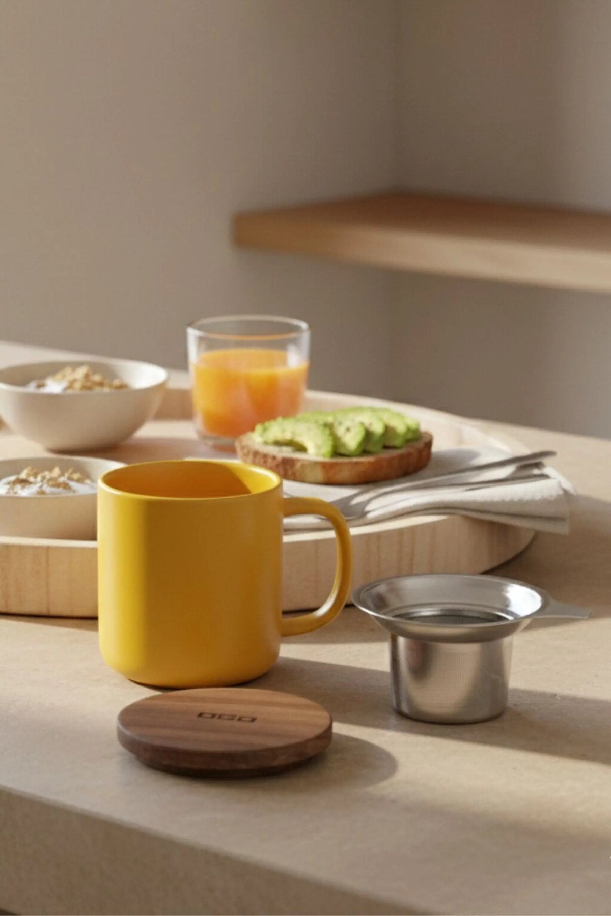 Juliet Yellow 300 ml tea mug with acacia lid on a table with loose-leaf tea